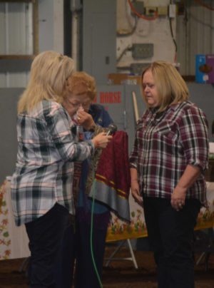 Patti Fischer gives scarves to Janet Fender and Phyllis Wycoff in memory of their husbands, Dennis Fender and Bill Wycoff during the llama show at the fairgrounds on Sunday, Oct. 2. The show was dedicated to their memory. Beth Scott | Beacon