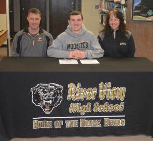 Caden Croft, center, signed his letter of intent to play football at the College of Wooster on Feb. 1 in the library at River View High School. He is pictured with his dad Whit Croft and mother Leslie Croft. Josie Sellers | Beacon