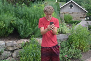 Adam Alvarez is pictured using his phone at Clary Gardens to play Pokémon Go. Josie Sellers | Beacon