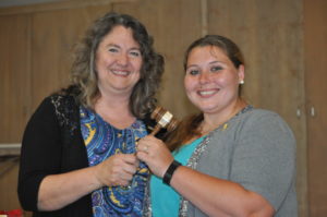 Outgoing club President Chris Sycks is presented with her ceremonial gavel from incoming club President Allyssa McMullen. Mark Fortune | Beacon