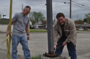 Century National Bank donated the light poles that were on the site of the bank’s additional Coshocton branch which will be located on North Third Street following construction. Pictured are Hubie Cushman, (left) Indian Mud Run organizer and Vic Allen of Allen Construction who donated his time and equipment to remove the light poles. The poles will be used for an obstacle on the Indian Mud Run course. Mark Fortune | Beacon