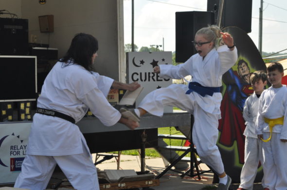 Students from Jon McFarland’s Champion Martial Arts classes took turns breaking boards with messages written by area cancer survivors on Saturday morning, May 13 at the fairgrounds during the 22nd annual Relay for Life event. Mark Fortune | Beacon