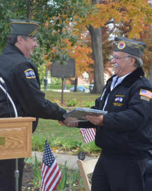 Veterans Service Officer Jim Barstow presented Herb Tidrick with a plaque honoring him for his dedication to helping veterans in our community. Tidrick retired from the veterans’ service office on Nov. 11 and was the main speaker at the Veterans Day ceremony on the court square. Both Barstow and Tidrick are veterans of the U.S. Navy.  Josie Sellers | Beacon