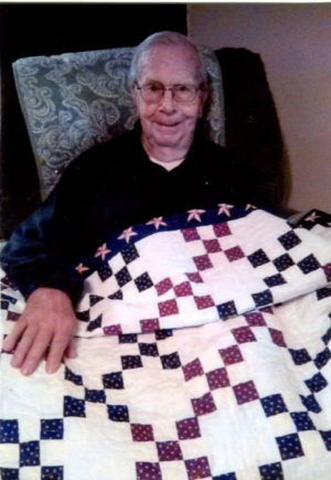 Dick Scherer smiles while showing off the patriotic quilt he received from a project worked on by the Coshocton Elks Lodge 376 and the Coshocton Canal Quilters. Contributed | Beacon