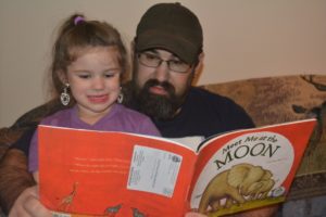 Sophia Sellers, a participant in the Dolly Parton Imagination Library program, is pictured reading with her father, Eric Sellers. Contributed | Beacon